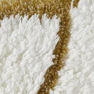 Close-up of ivory and gold cotton terry bath rug border detail.