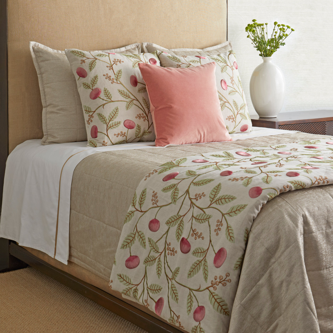 Close-up of Ann Gish Joliet pillow styled on bed with floral berry bedding and pink velvet accent pillow.