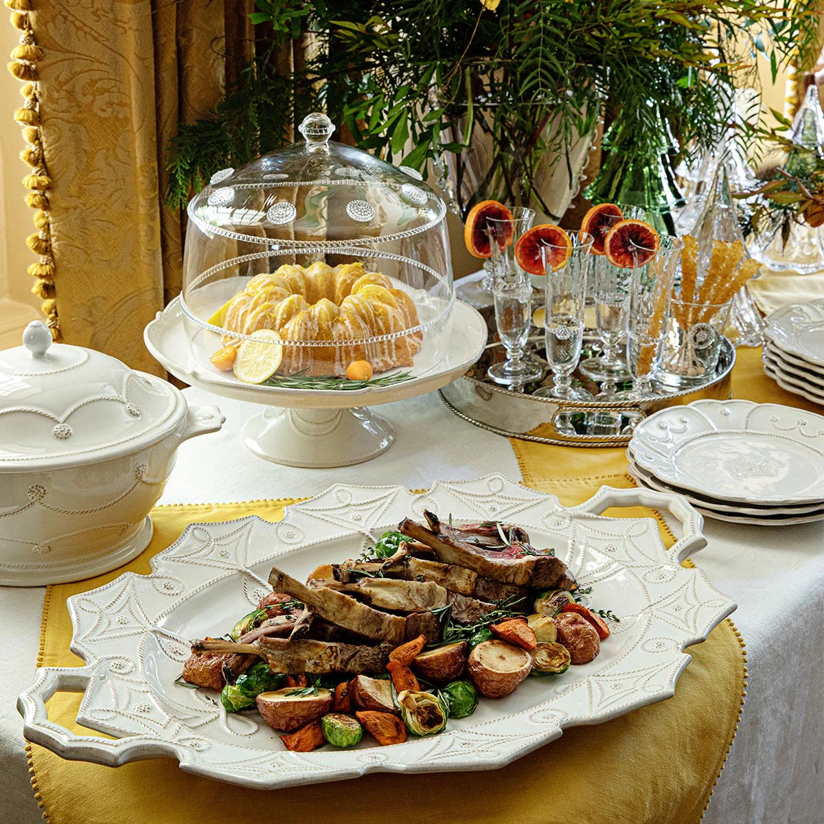 Juliska Jardins du Monde white embossed platter styled with roasted vegetables on a gold-trimmed table.