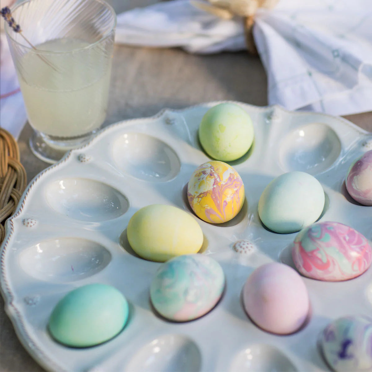 Juliska Berry & Thread platter styled with pastel marbled Easter eggs and a citrus drink.