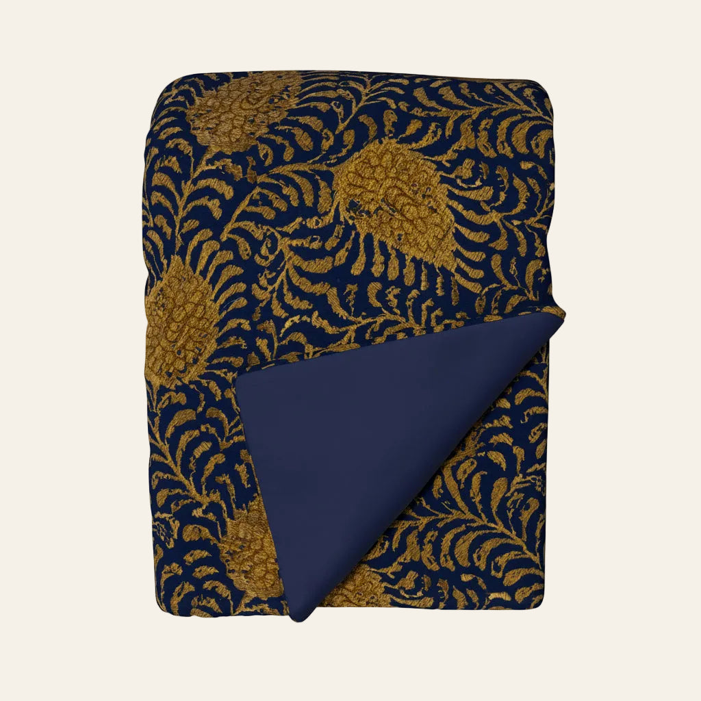 Ann Gish Kinrande throw in navy with gold botanical jacquard pattern, solid navy reverse.