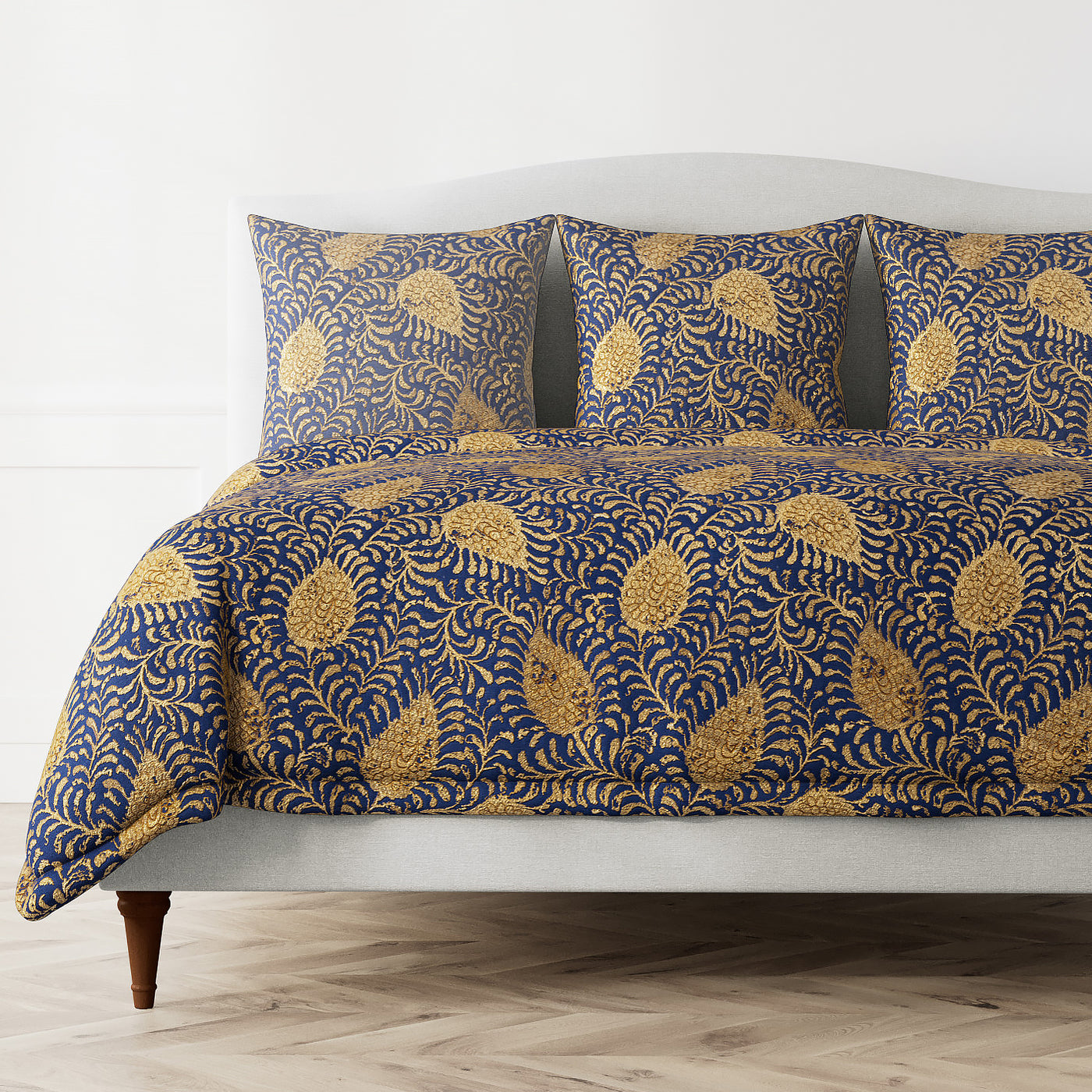Ann Gish Kinrande duvet cover in navy and gold botanical paisley pattern on styled bed.