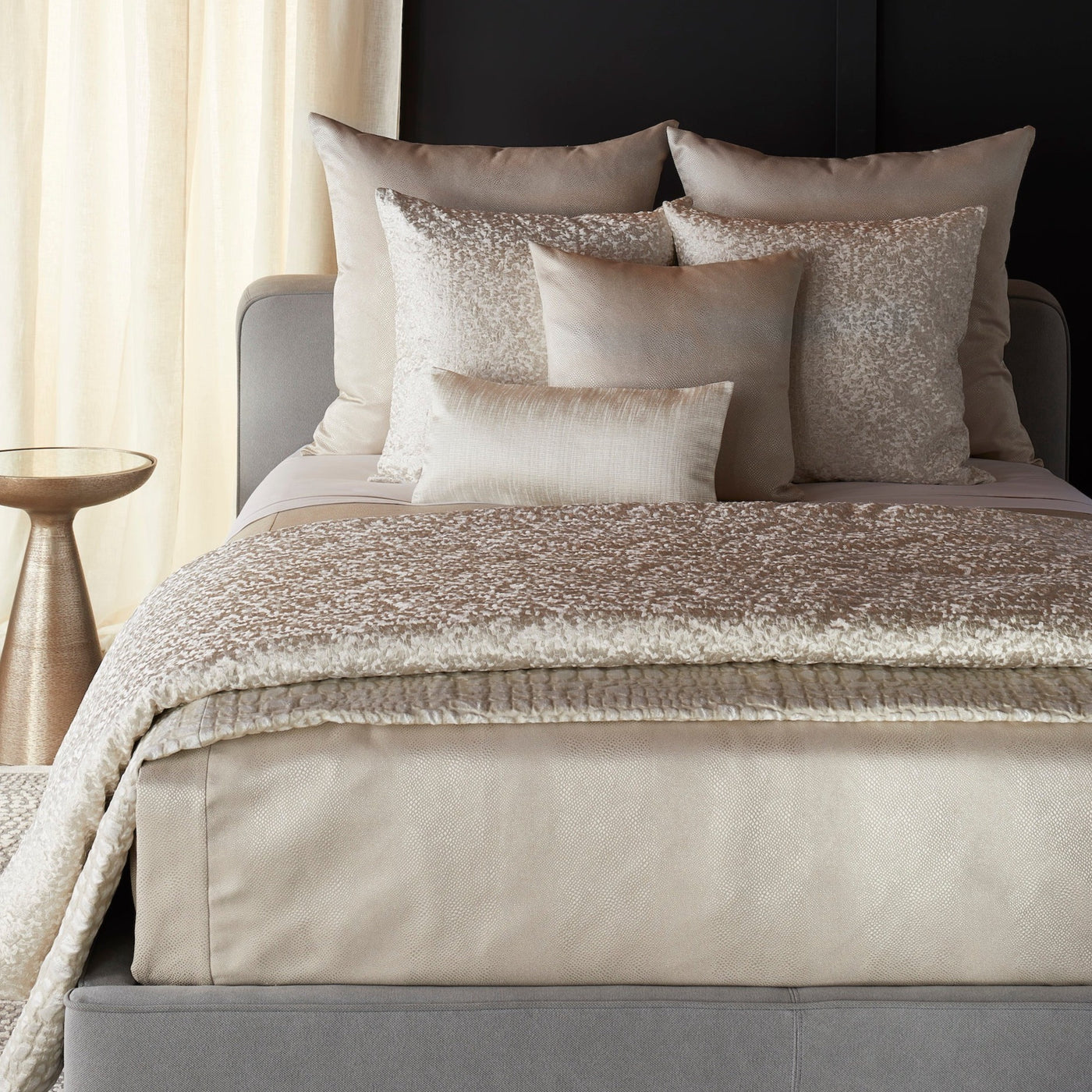 Champagne velvet coverlet with shimmering mosaic pattern, styled on bed with matching pillows.