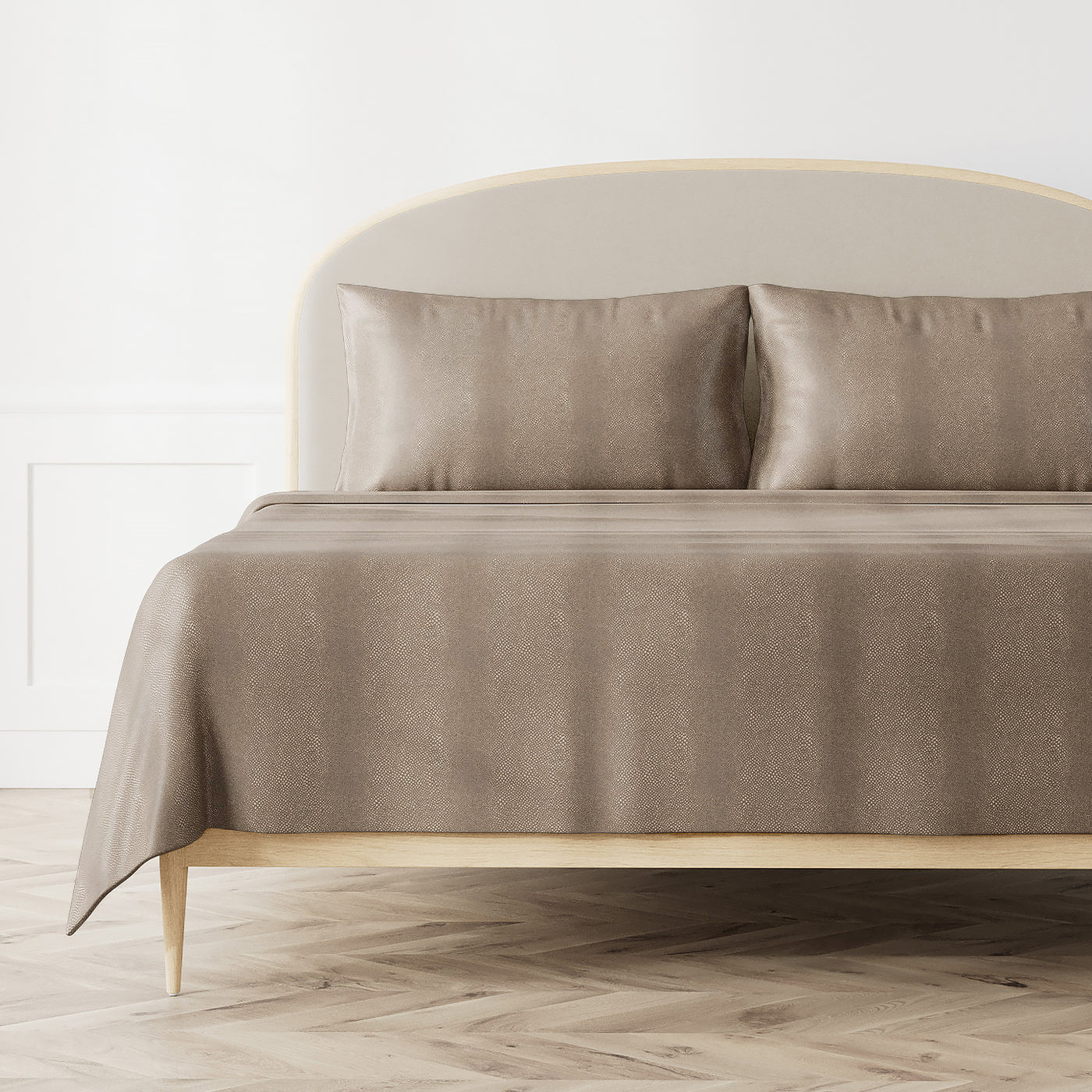 Ann Gish Komodo coverlet in taupe, styled on a bed with matching pillowcases.
