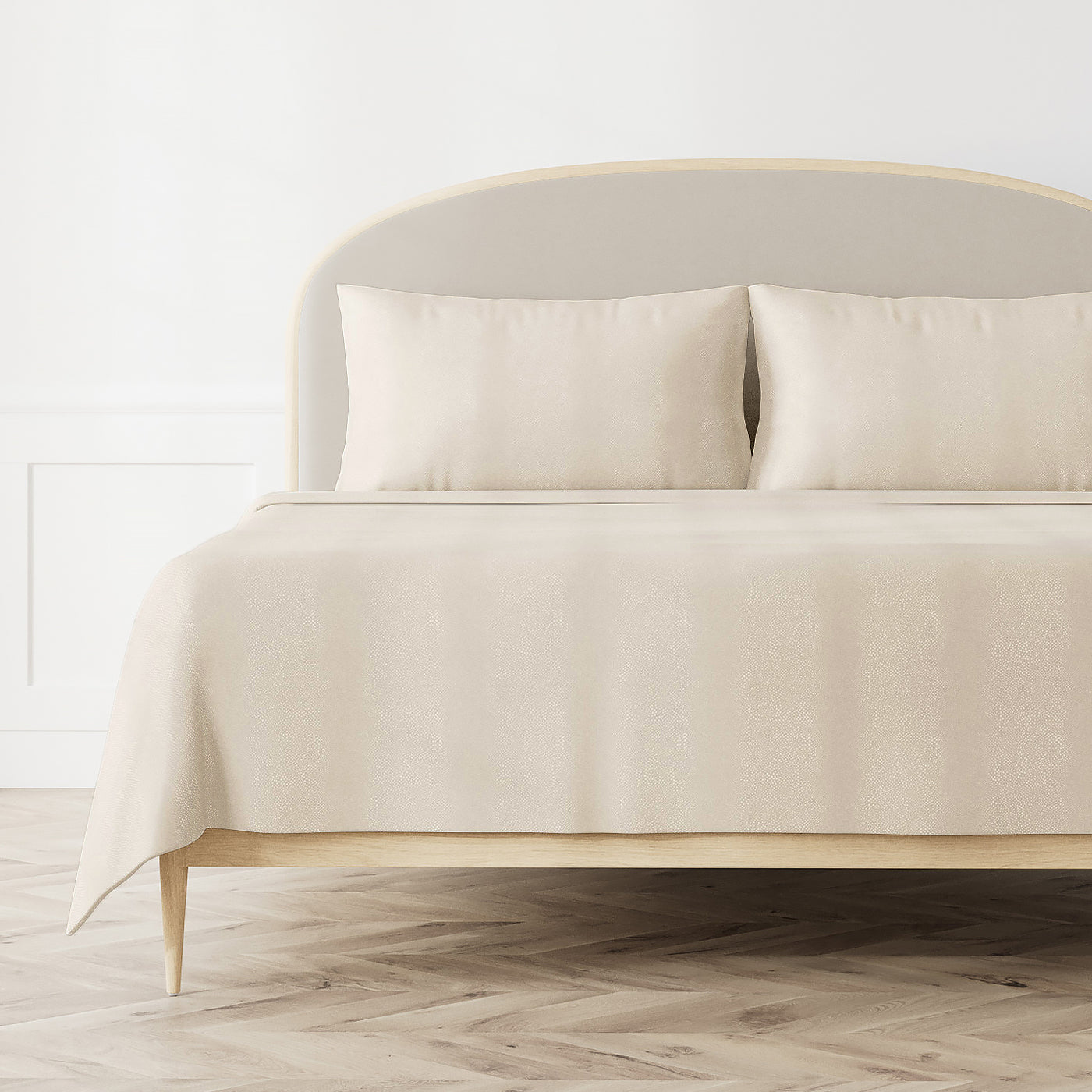 Ann Gish Komodo coverlet in ivory draped over a styled bed with matching shams.