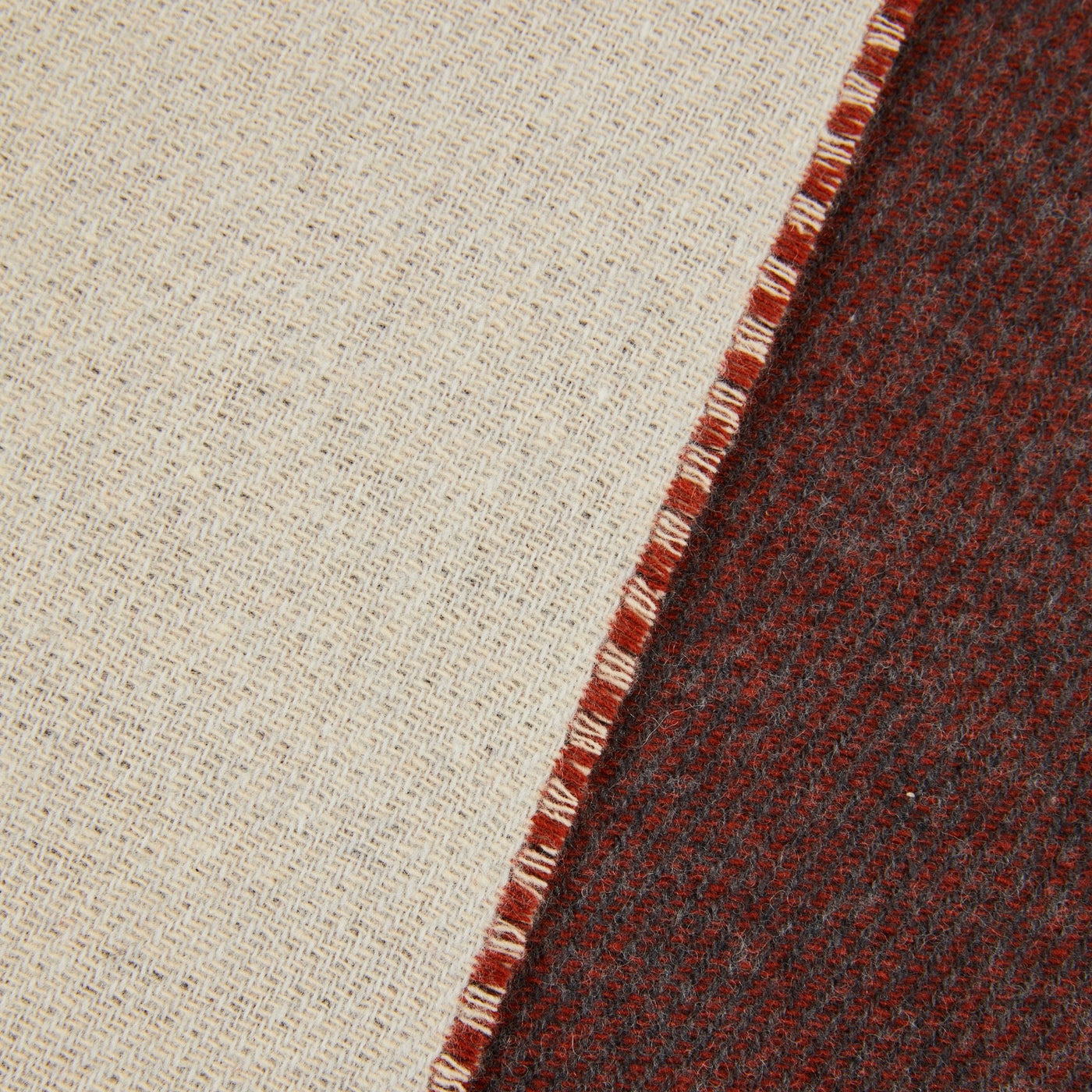 Close-up of Lanerossi Ascot throw showing ivory reverse and crimson-charcoal face with blanket-stitch edge.