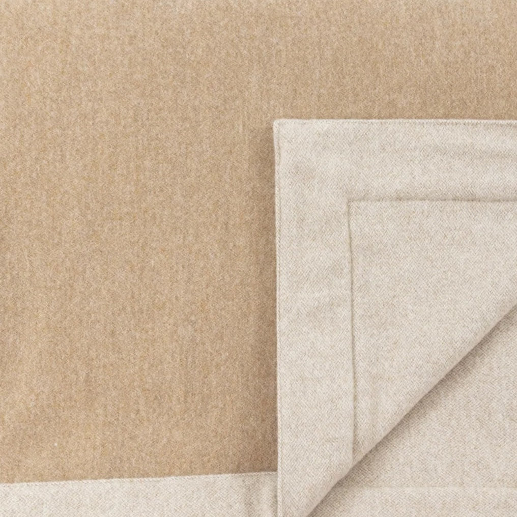 Corner fold detail showing camel and oatmeal reversible wool blanket faces.