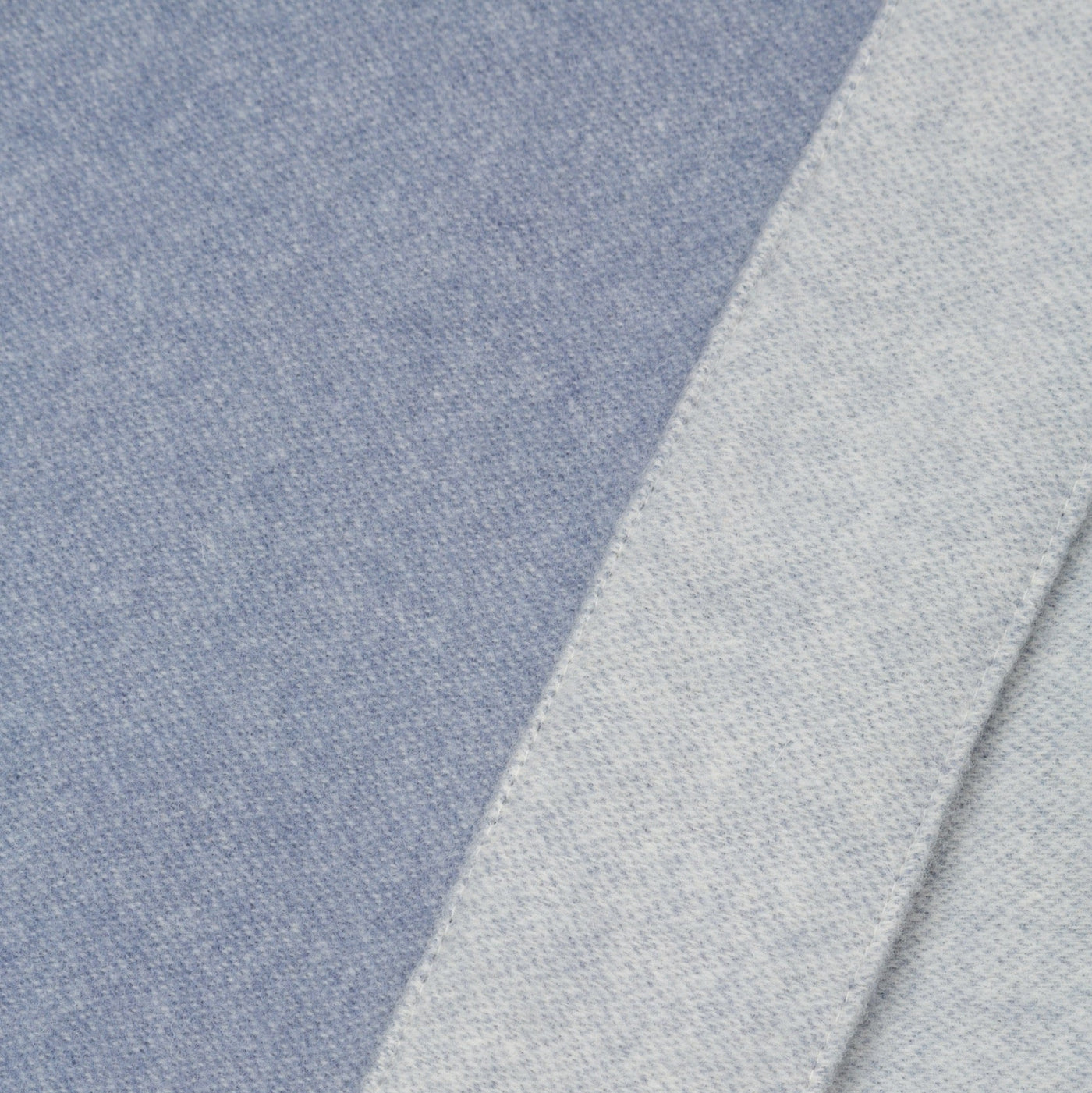 Close-up of Lanerossi Afrodite blanket showing blue and grey fabric faces with folded edge detail.