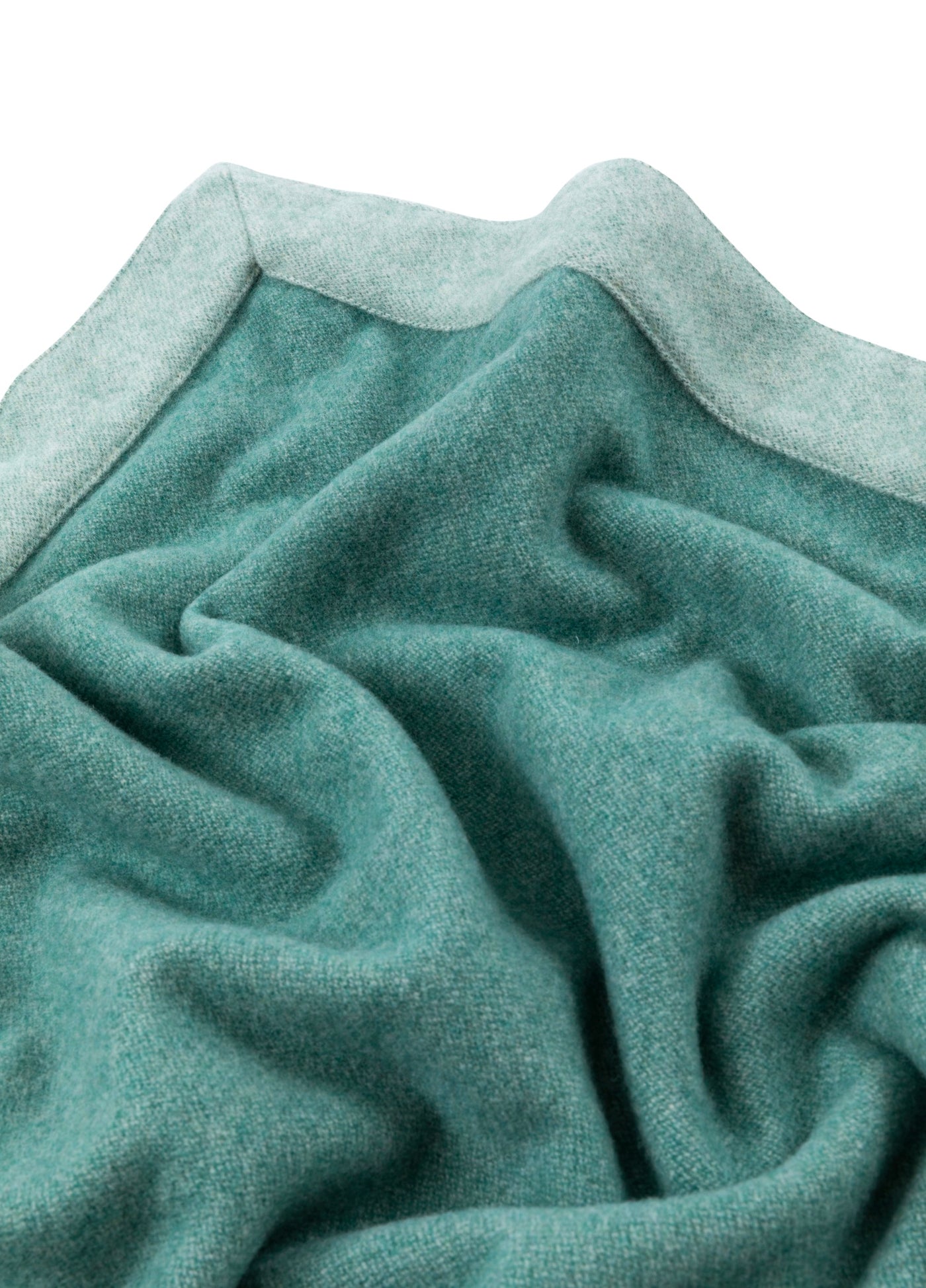 Close-up of teal Lanerossi Afrodite blanket, showing soft drape and contrast border trim.