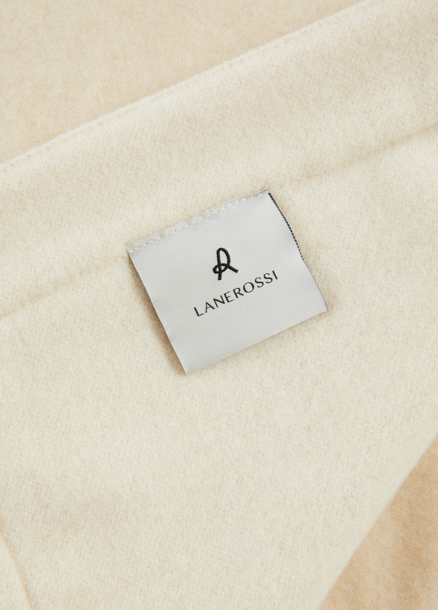 Close-up of Lanerossi woven label on ivory and champagne Afrodite blanket.