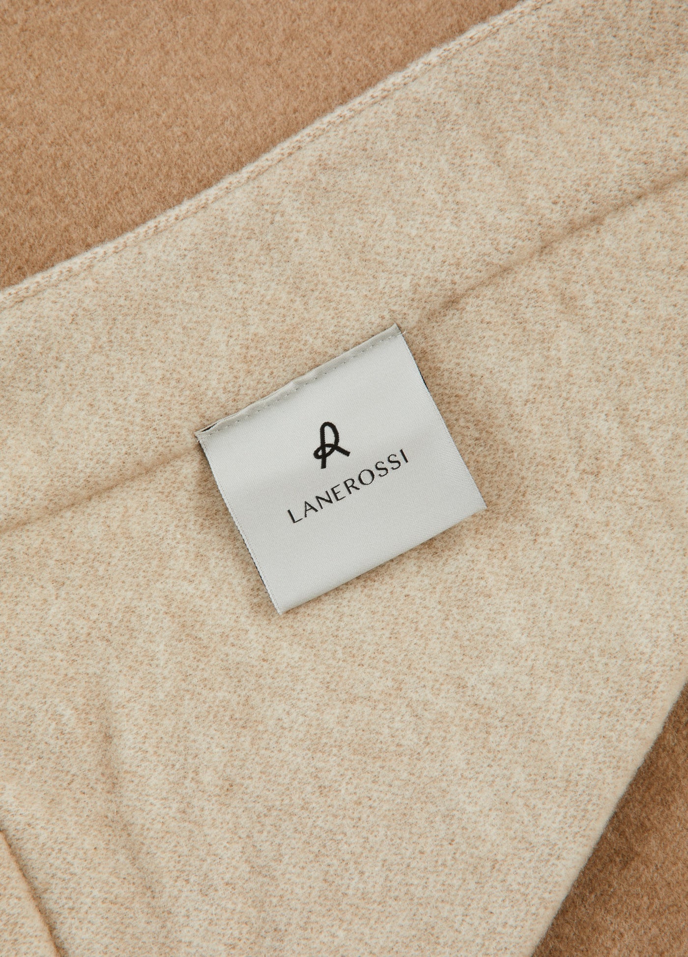 Close-up of Lanerossi Afrodite blanket label on oatmeal wool fabric with camel reverse.