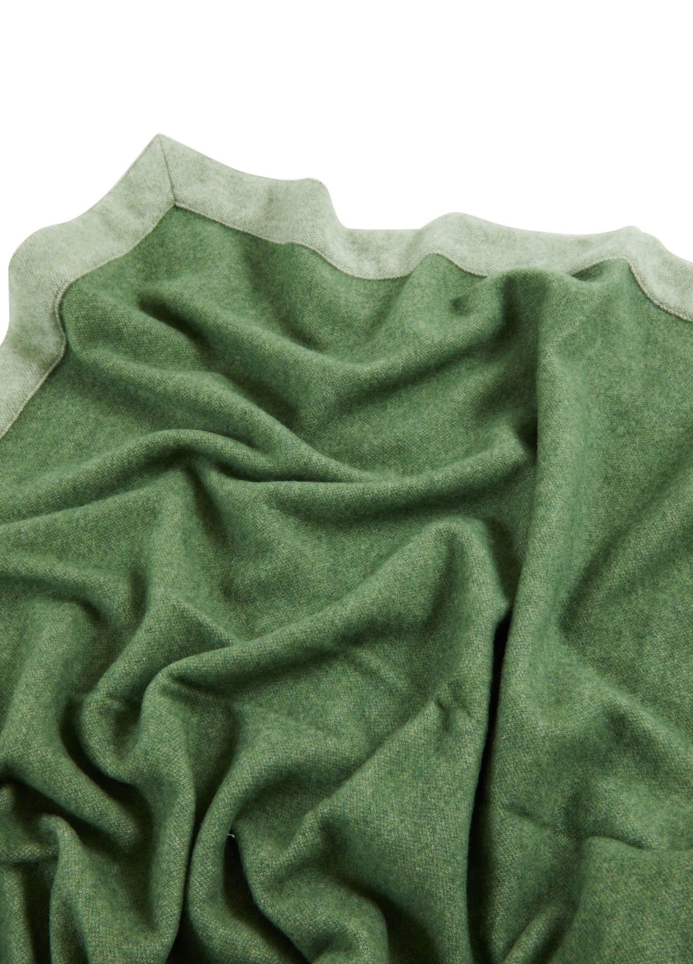 Close-up of Lanerossi Afrodite blanket in forest green, showing reversible sage lining and draped wool texture.