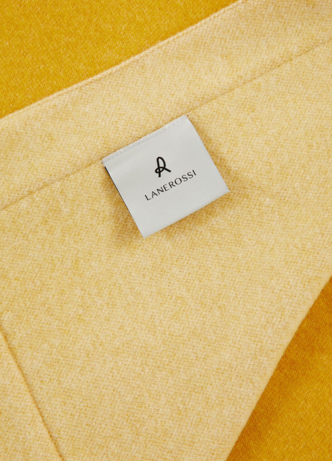 Close-up of Lanerossi Afrodite blanket label on golden yellow wool fabric.