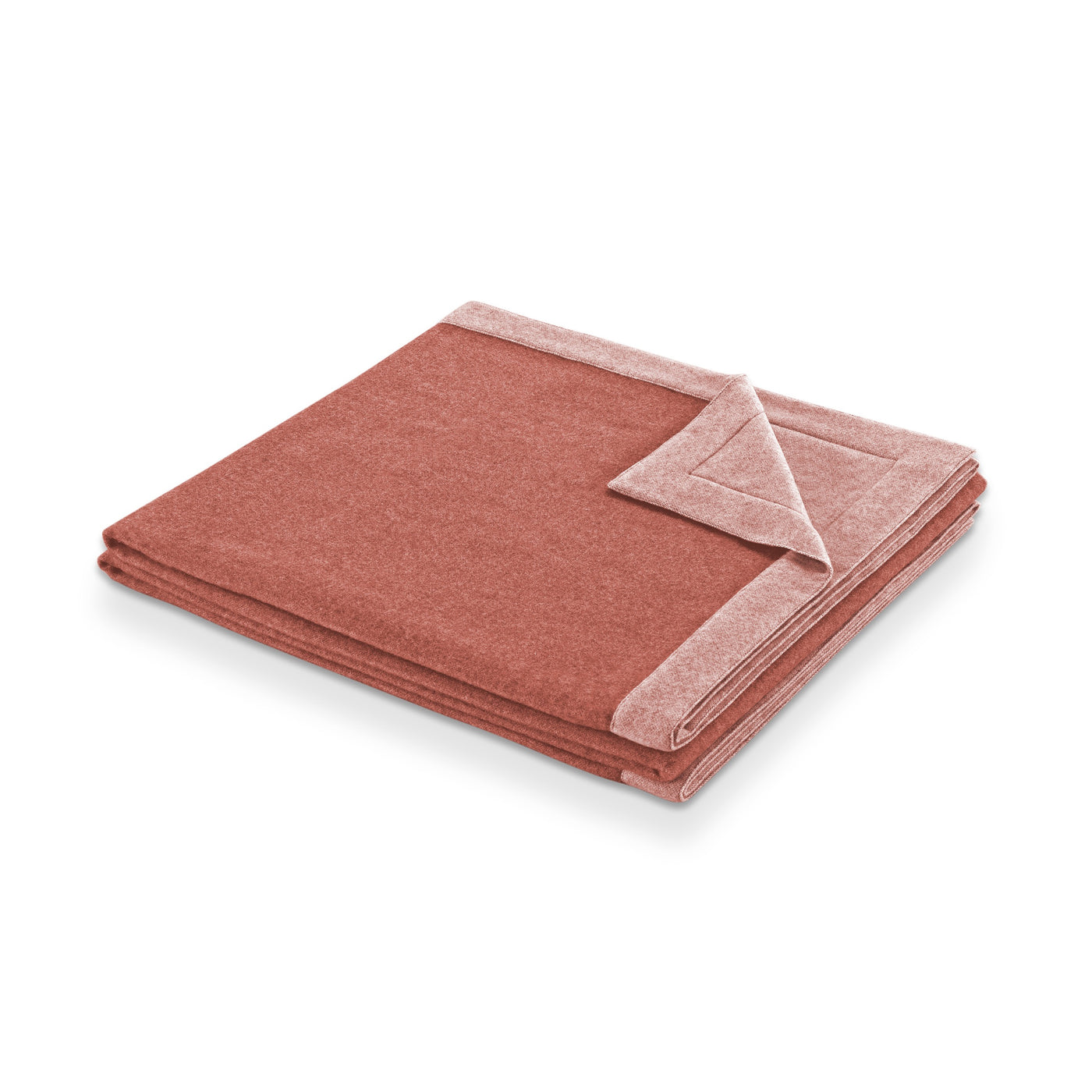Folded terracotta wool blanket with blush reverse, corner turned back to show two-tone contrast.