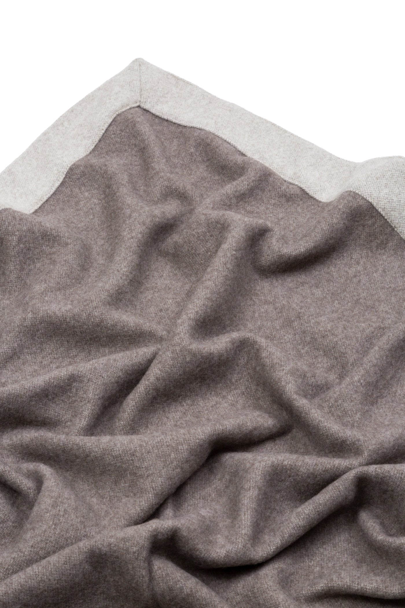 Close-up of draped taupe wool blanket with contrast silver grey border trim.