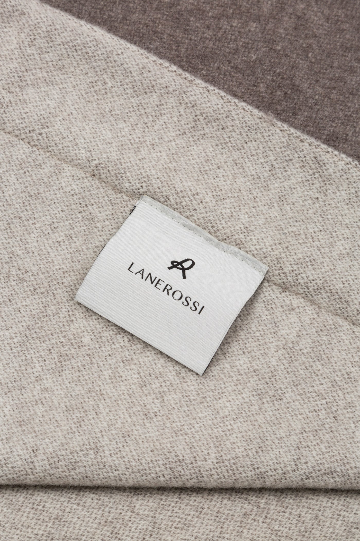 Close-up of Lanerossi Afrodite blanket label on taupe wool fabric with contrast border detail.