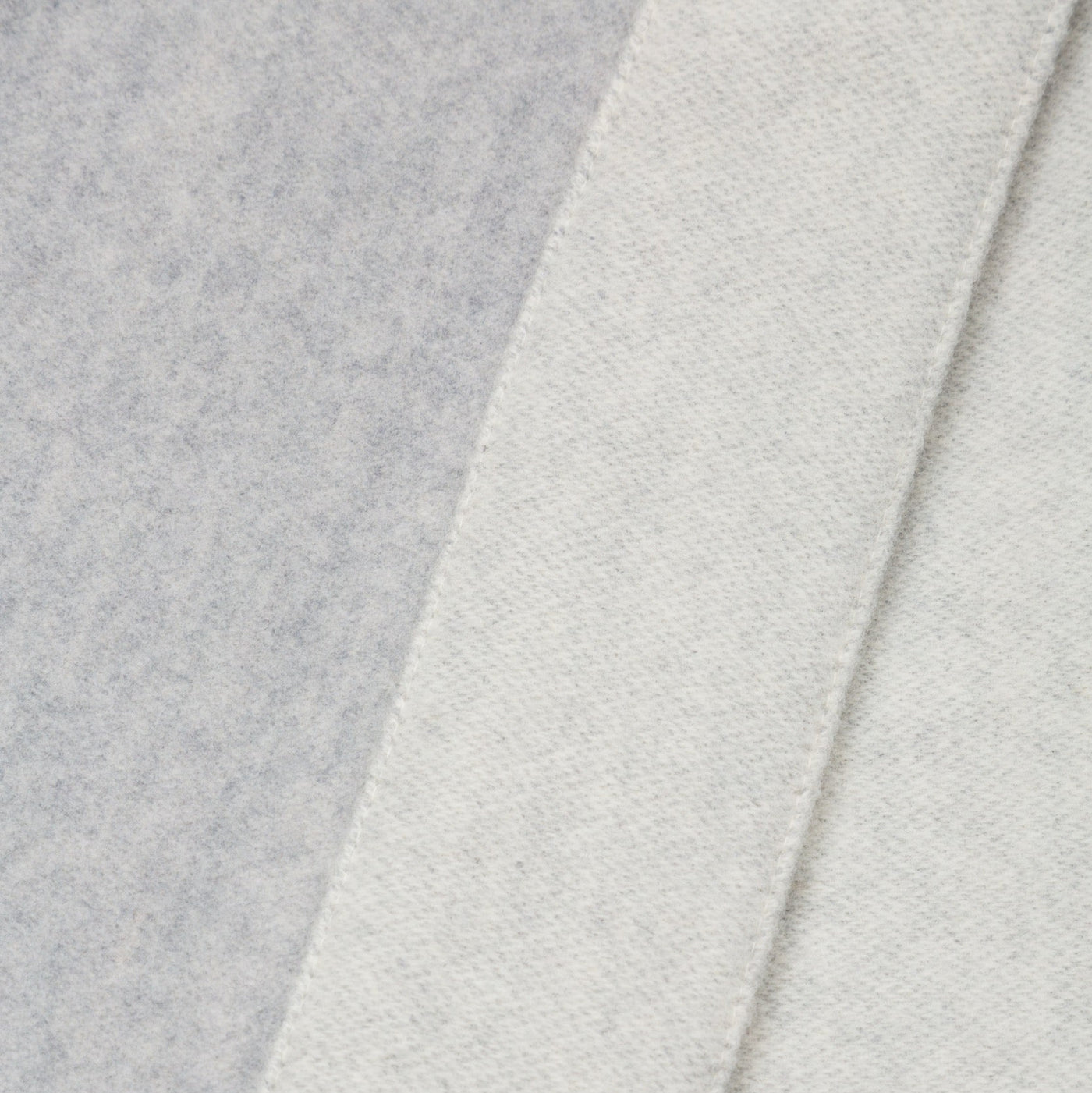 Close-up of layered Afrodite blanket panels in soft grey and ivory wool fabric.