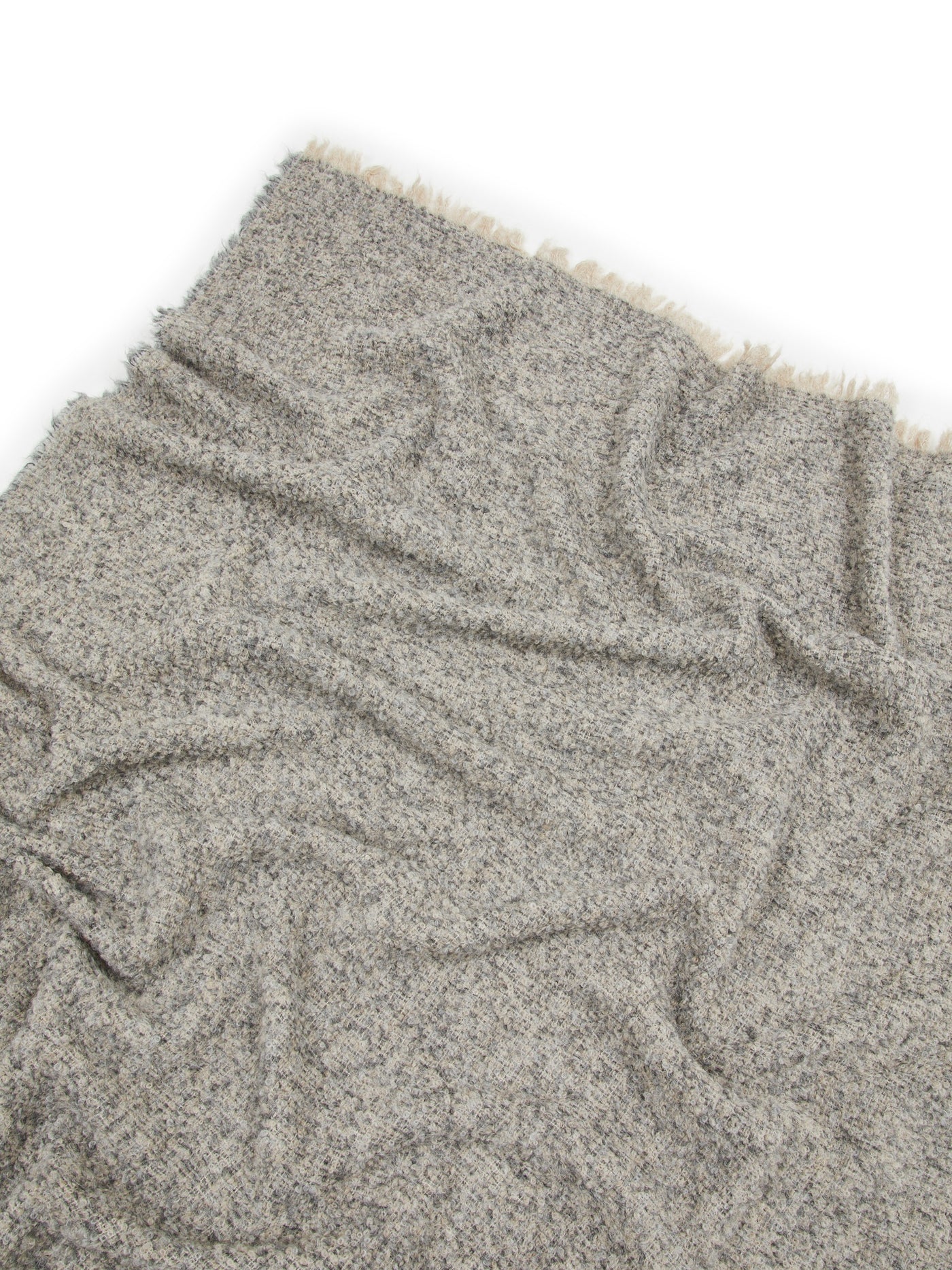 Close-up of Lanerossi Bogotà throw in heathered grey boucle with ivory fringe trim.