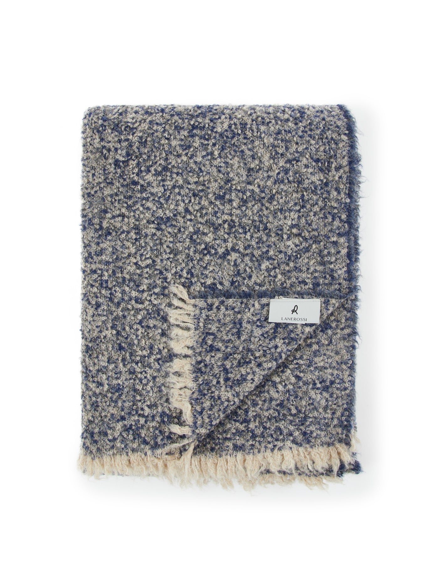 Folded navy and ivory boucle throw with fringe trim and woven brand label.