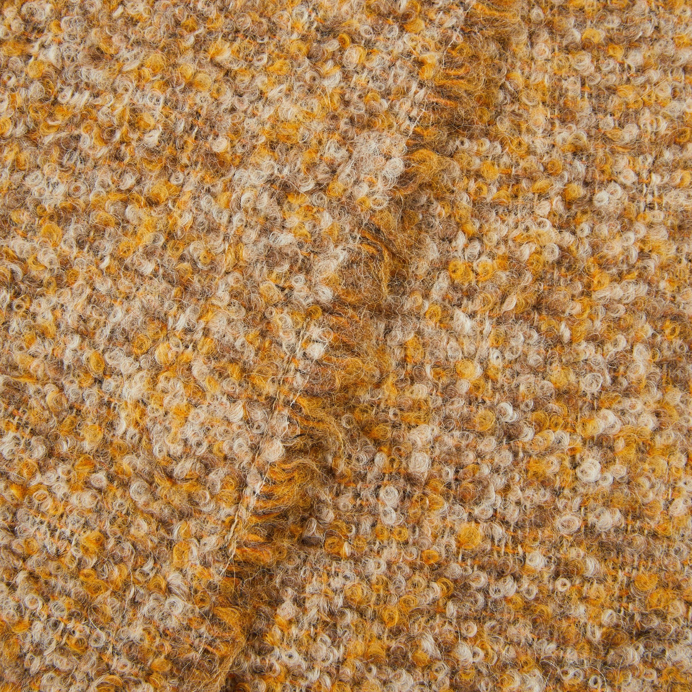 Close-up of Lanerossi Bogotà throw's boucle weave texture in saffron and oat tones.