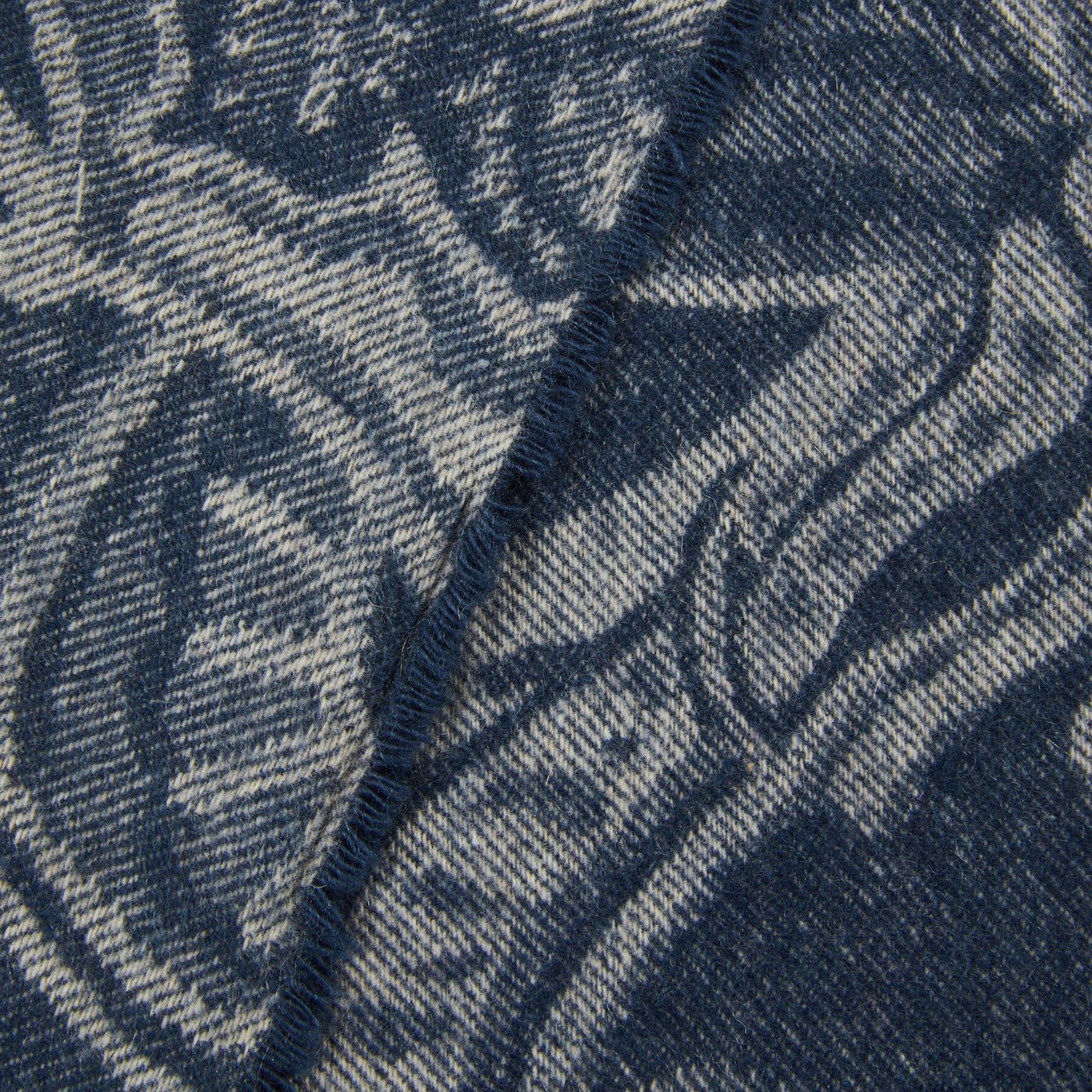Close-up of Lanerossi Bohémien throw's folded edge, navy and grey botanical jacquard weave.
