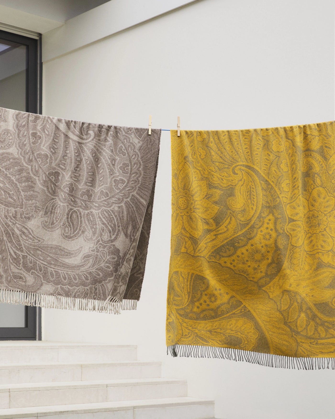 Lanerossi Bohémien throws in taupe and saffron paisley hanging outdoors on a line.
