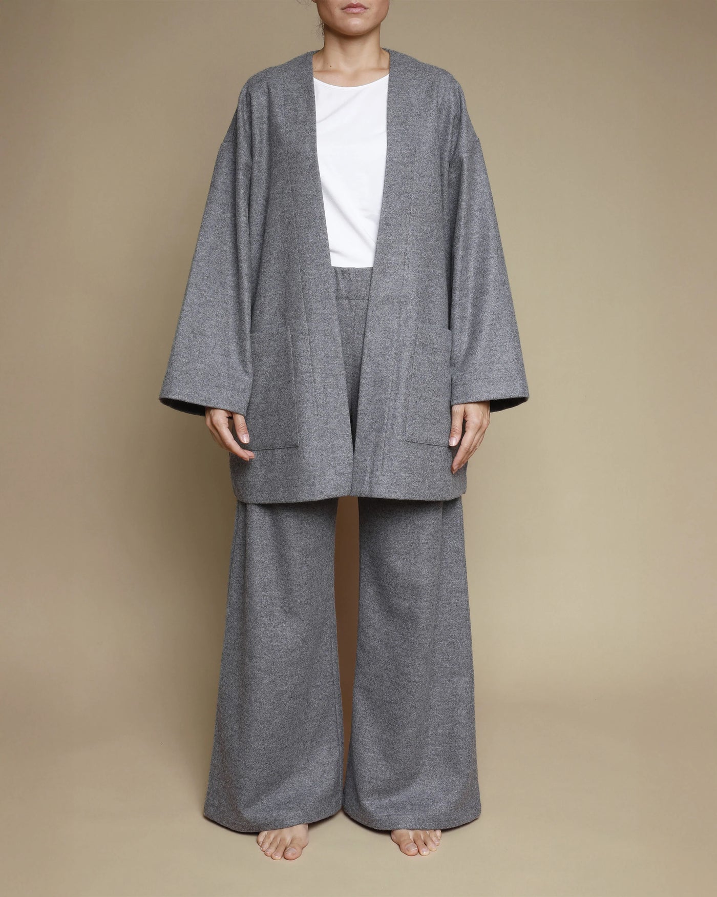 Grey merino oversized cardigan styled open over matching wide-leg trousers, front view.