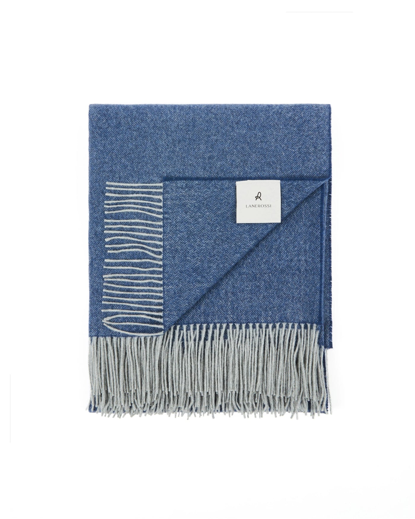 Folded navy and grey Cassiopea throw with fringed edge and woven label detail.