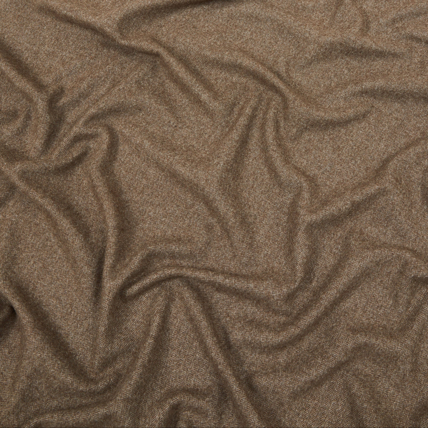 Close-up of draped mocha wool throw showing soft folds and fine heathered weave texture.