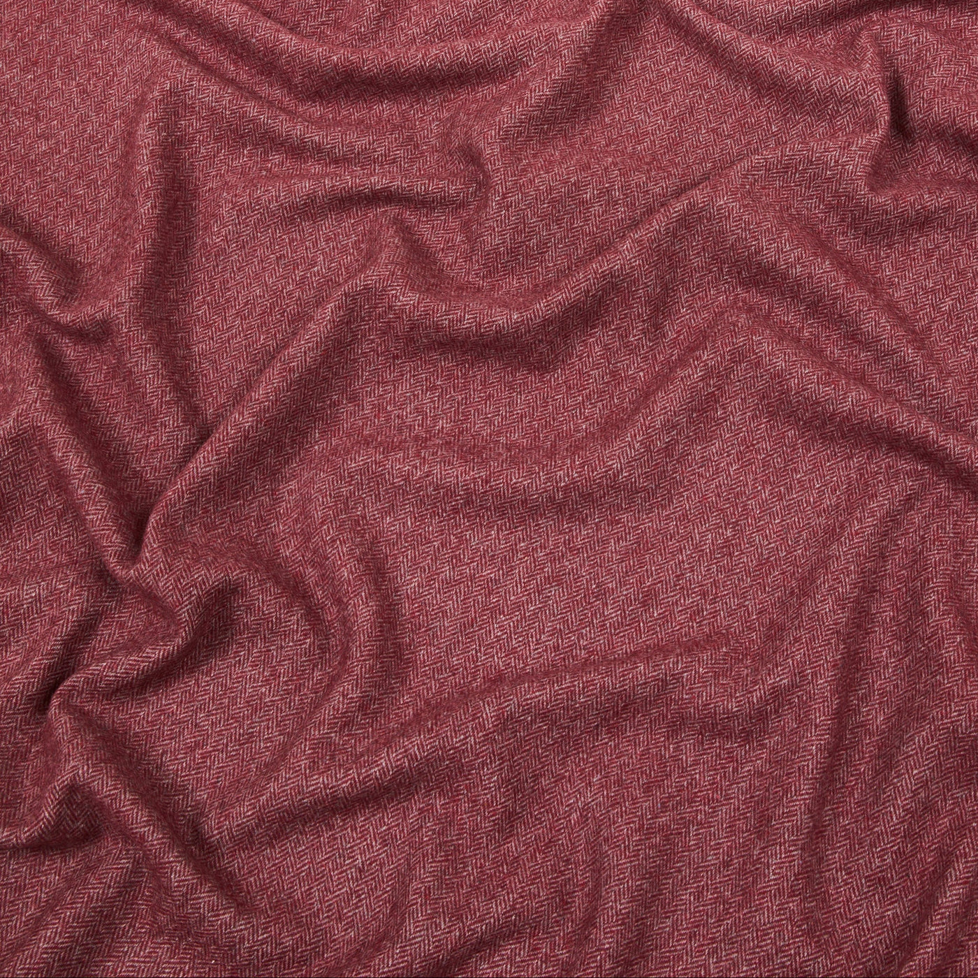 Close-up of draped burgundy melange wool throw, showing soft texture and natural folds.