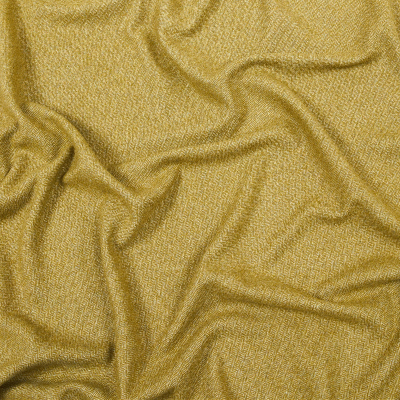 Lanerossi Cassiopea throw in gold, close-up of draped wool fabric texture.