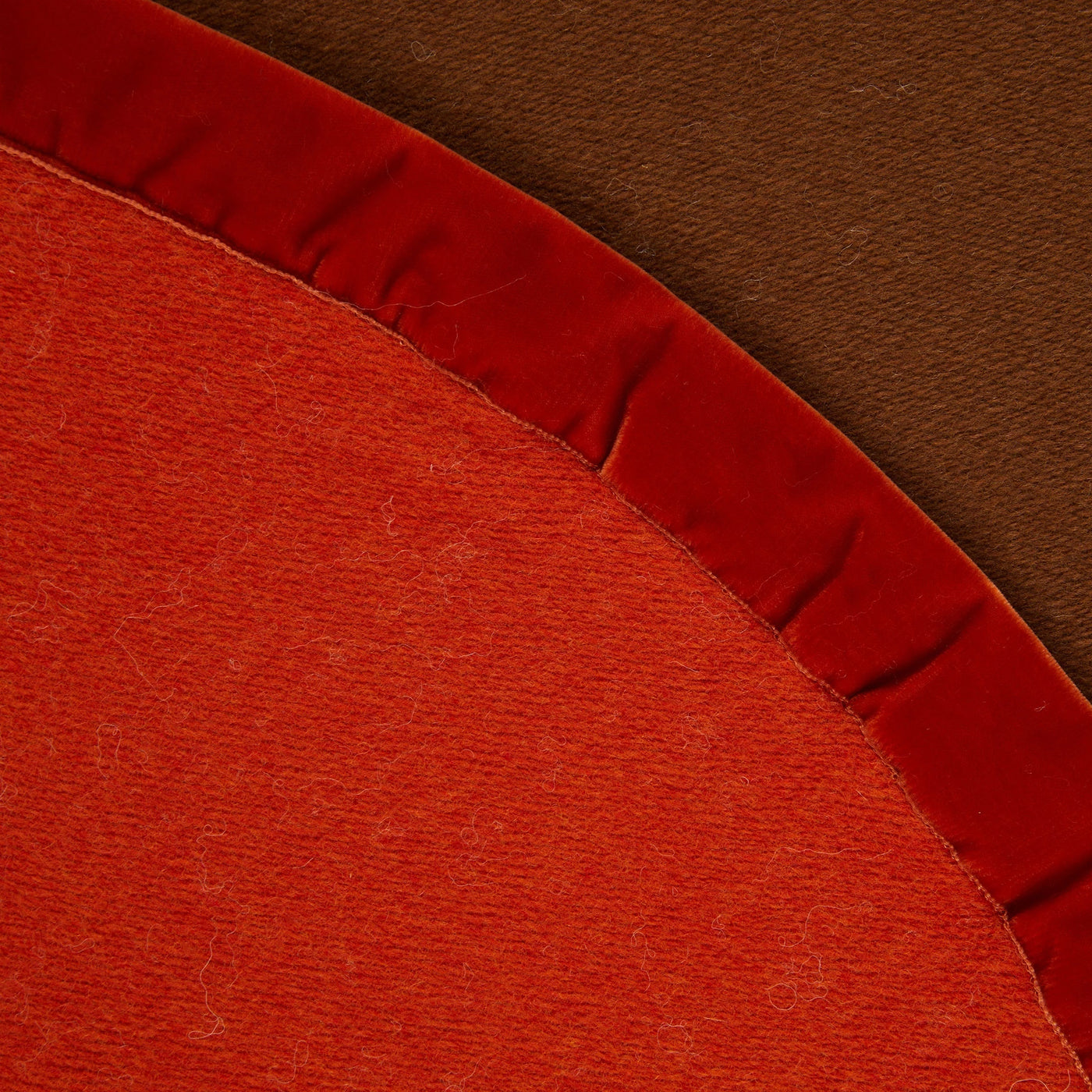 Close-up of burnt orange Lanerossi Thermo Blanket curved edge with velvet ruffle trim.