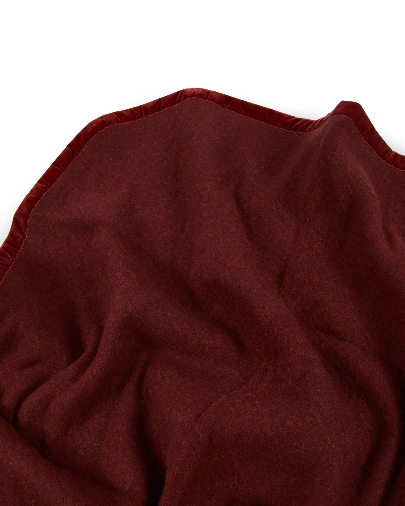 Close-up of Lanerossi Thermo Blanket in deep burgundy, showing soft draped fabric with stitched edge trim.