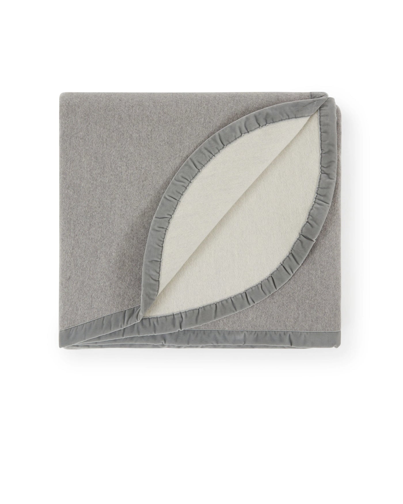 Folded grey blanket with ivory reverse and ruffle trim, corner turned back.