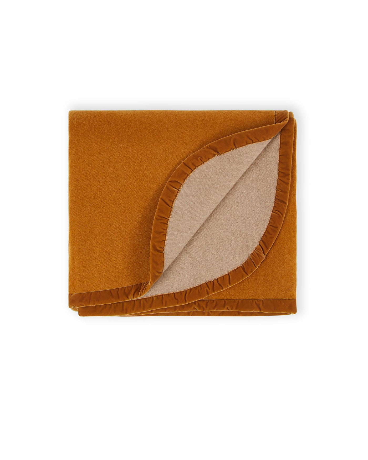 Folded amber wool blanket, corner turned back to reveal sand reverse with ruffled trim detail.