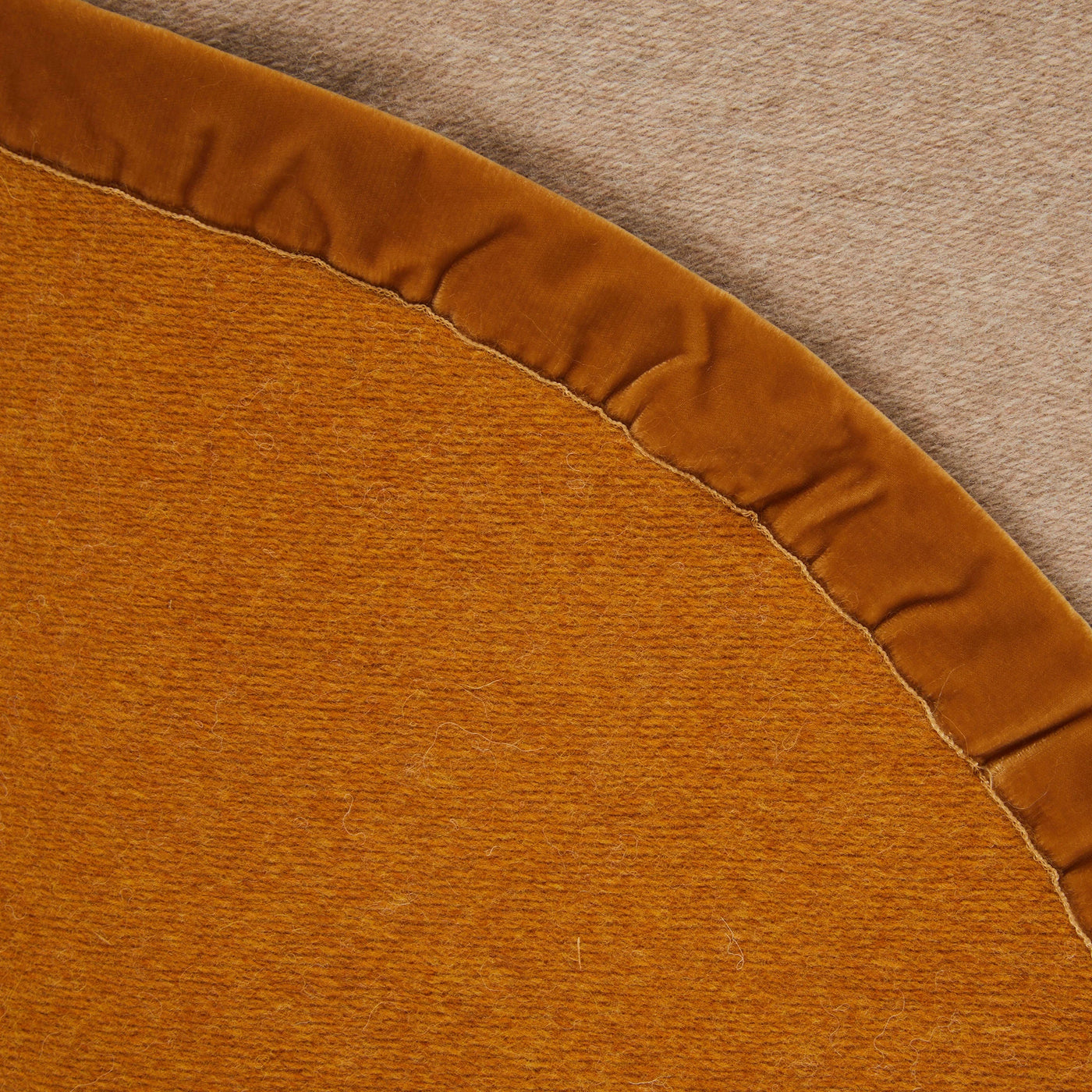 Close-up of Lanerossi amber thermo blanket curved edge with gathered velvet trim detail.