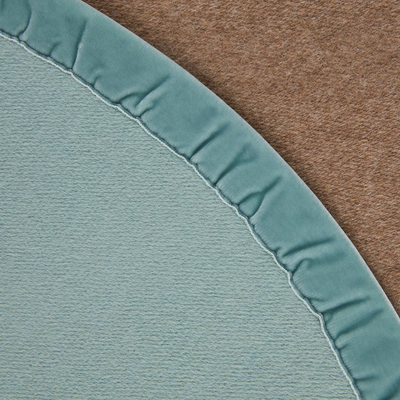 Close-up of Lanerossi Color thermo blanket corner in sage, showing satin binding edge detail.