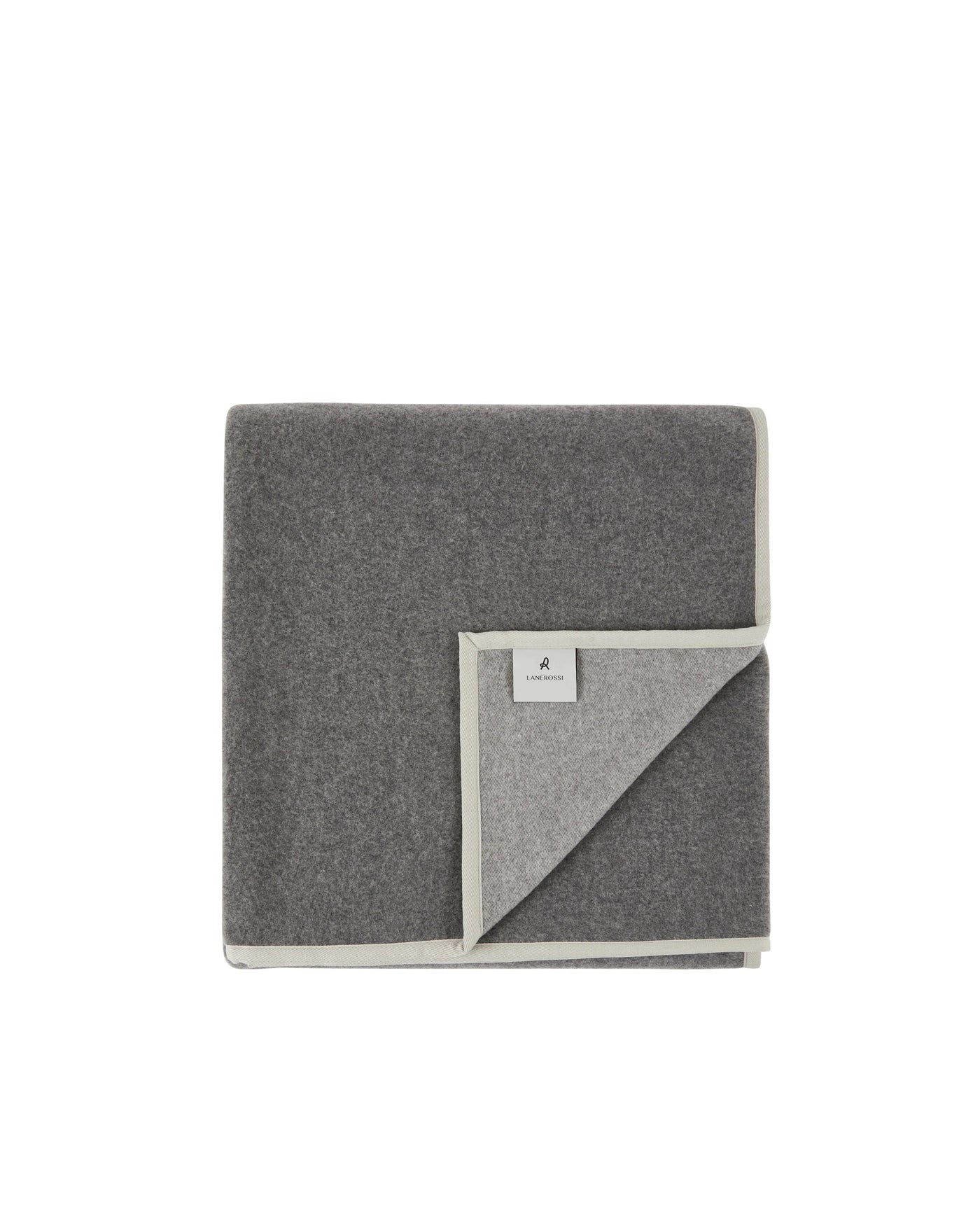 Folded charcoal wool blanket with contrast silver-grey reverse and small woven brand label.