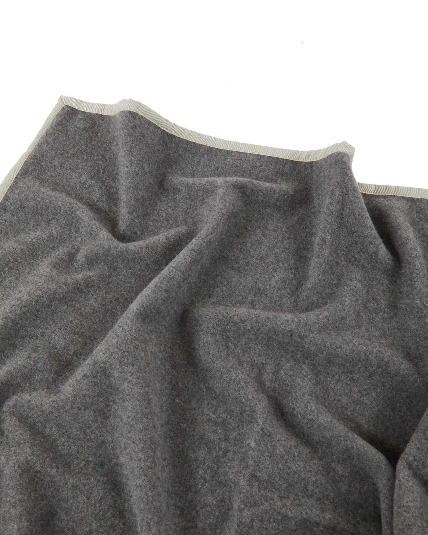 Charcoal wool blanket draped to show silver satin binding along top edge.