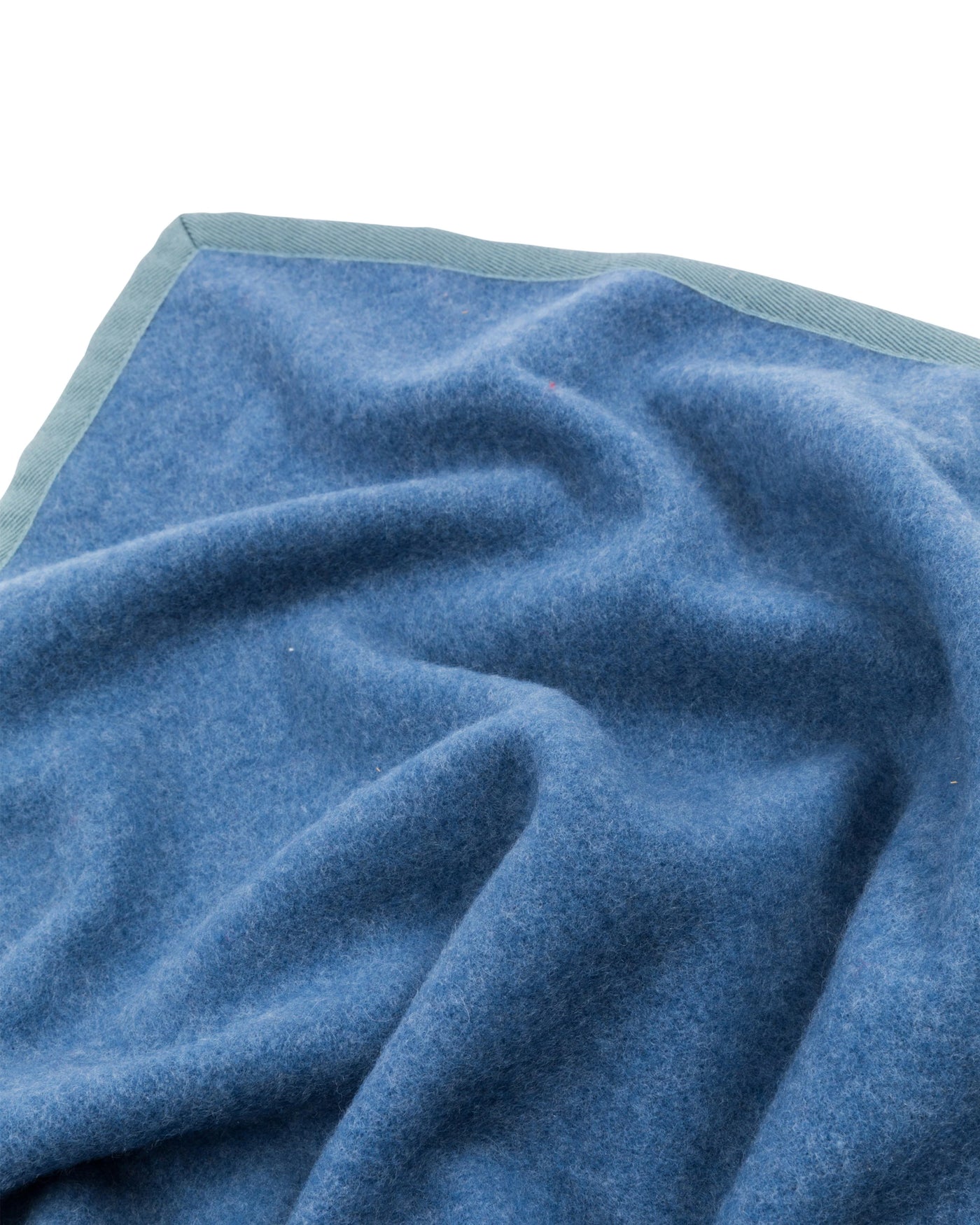 Close-up of Lanerossi Cortina blanket corner in blue with contrast sage trim.