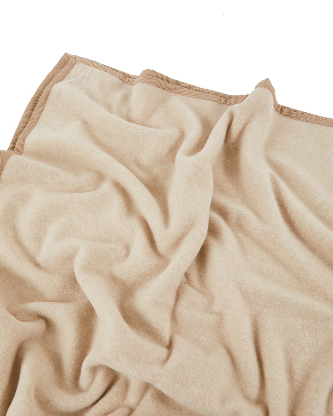 Camel-toned blanket with contrast border trim, draped to show soft woven texture.