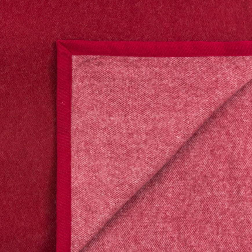 Close-up of Lanerossi Cortina blanket corner showing crimson wool face and rose-toned reverse with satin trim.