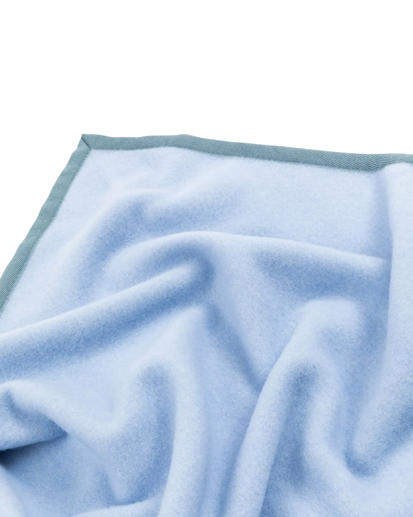 Close-up of Lanerossi Cortina blanket in sky blue with contrast sage border trim.