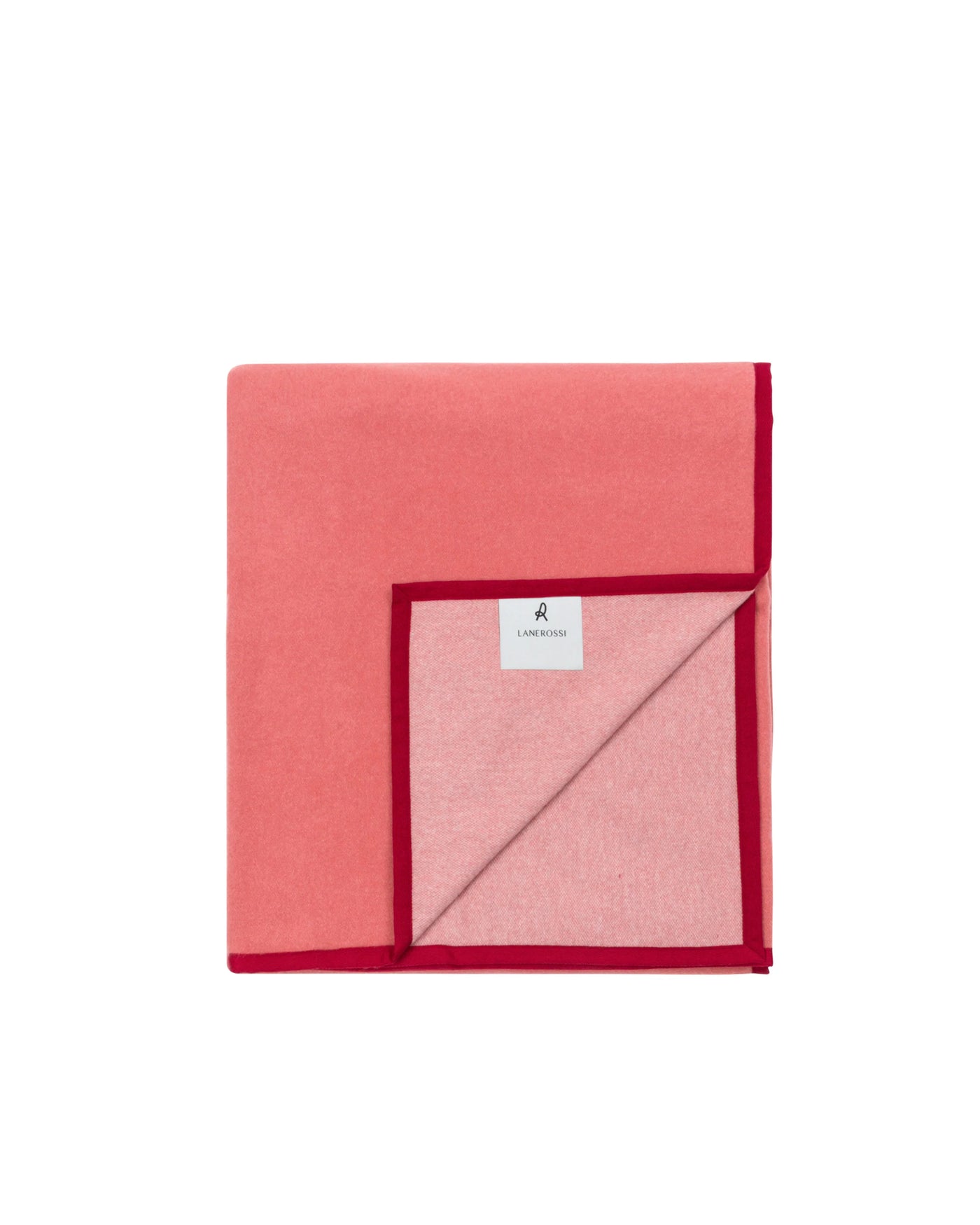 Coral and blush reversible blanket with deep red trim, folded flat showing both sides.
