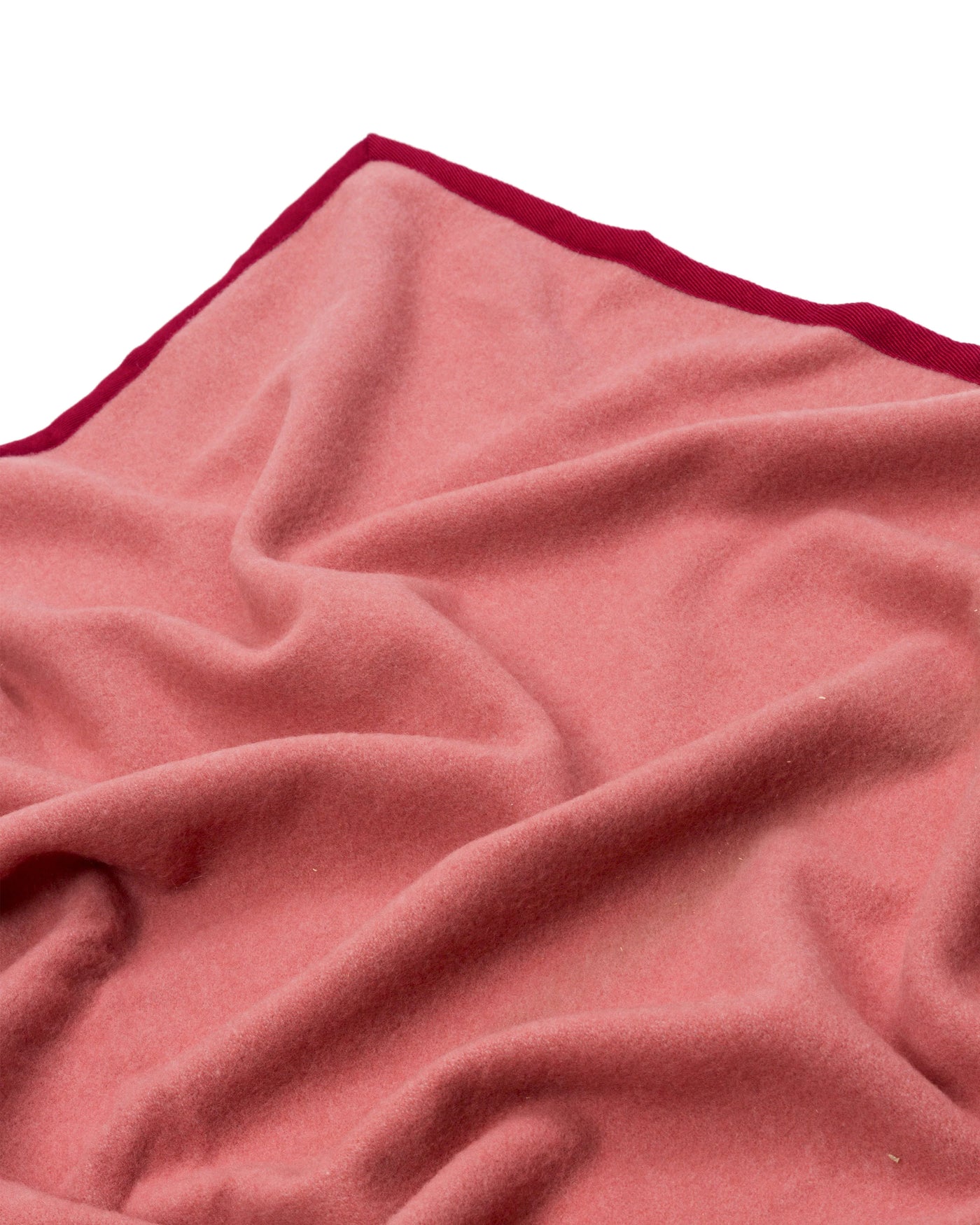 Close-up of Lanerossi Cortina blanket in rose with deep red contrast trim edge.