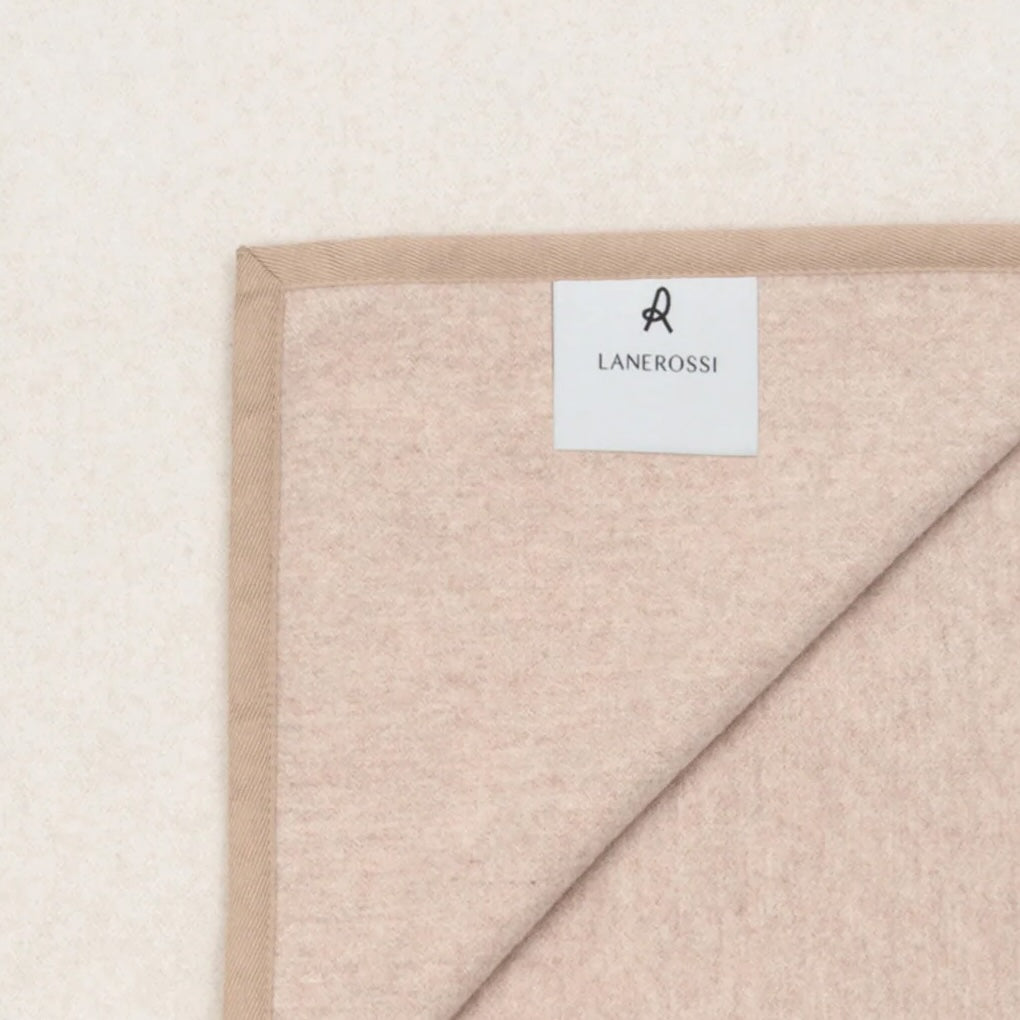 Corner detail of a Lanerossi Cortina blanket in blush, showing label and folded edge.