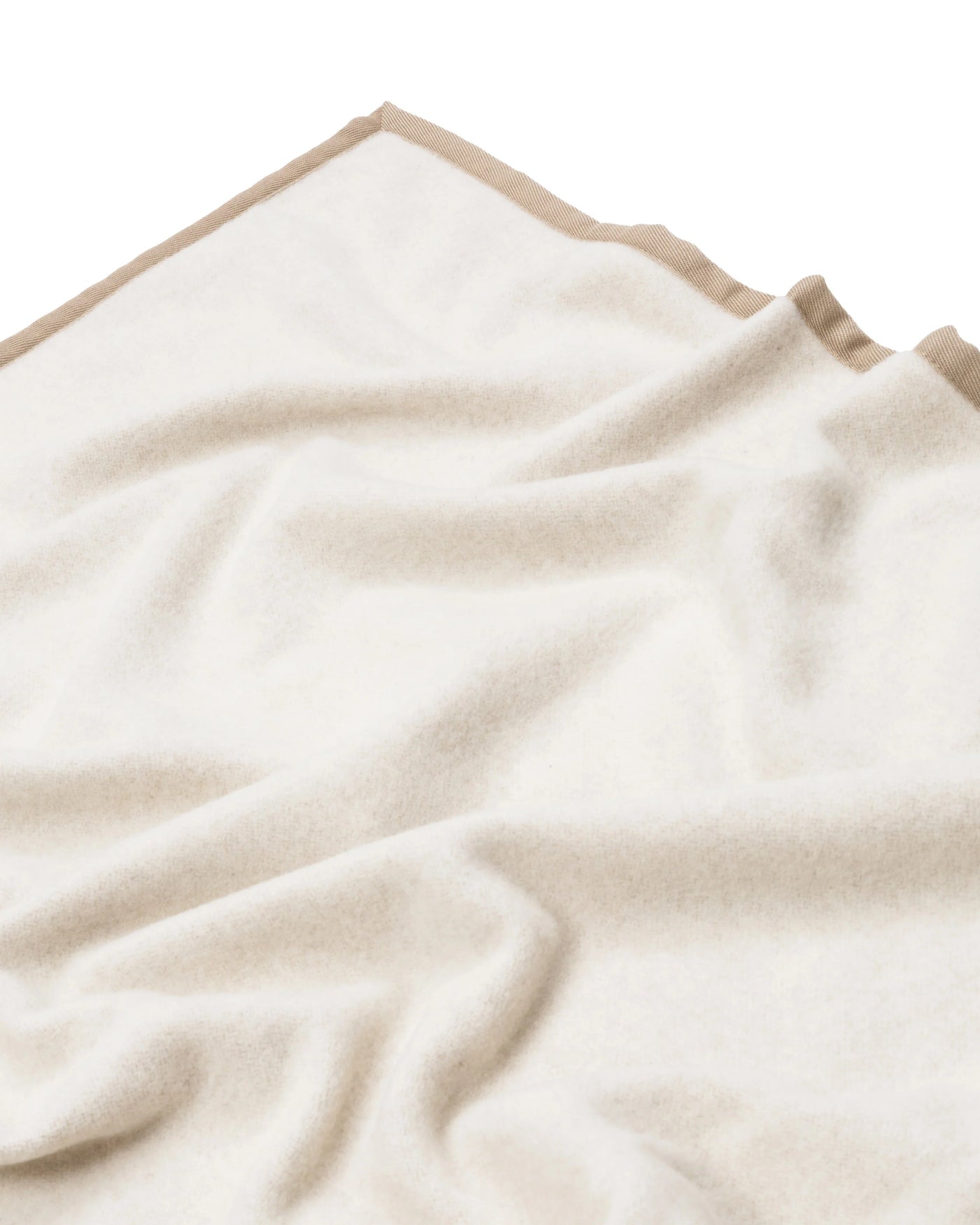Ivory wool blanket with contrasting sand trim, draped to show soft texture.
