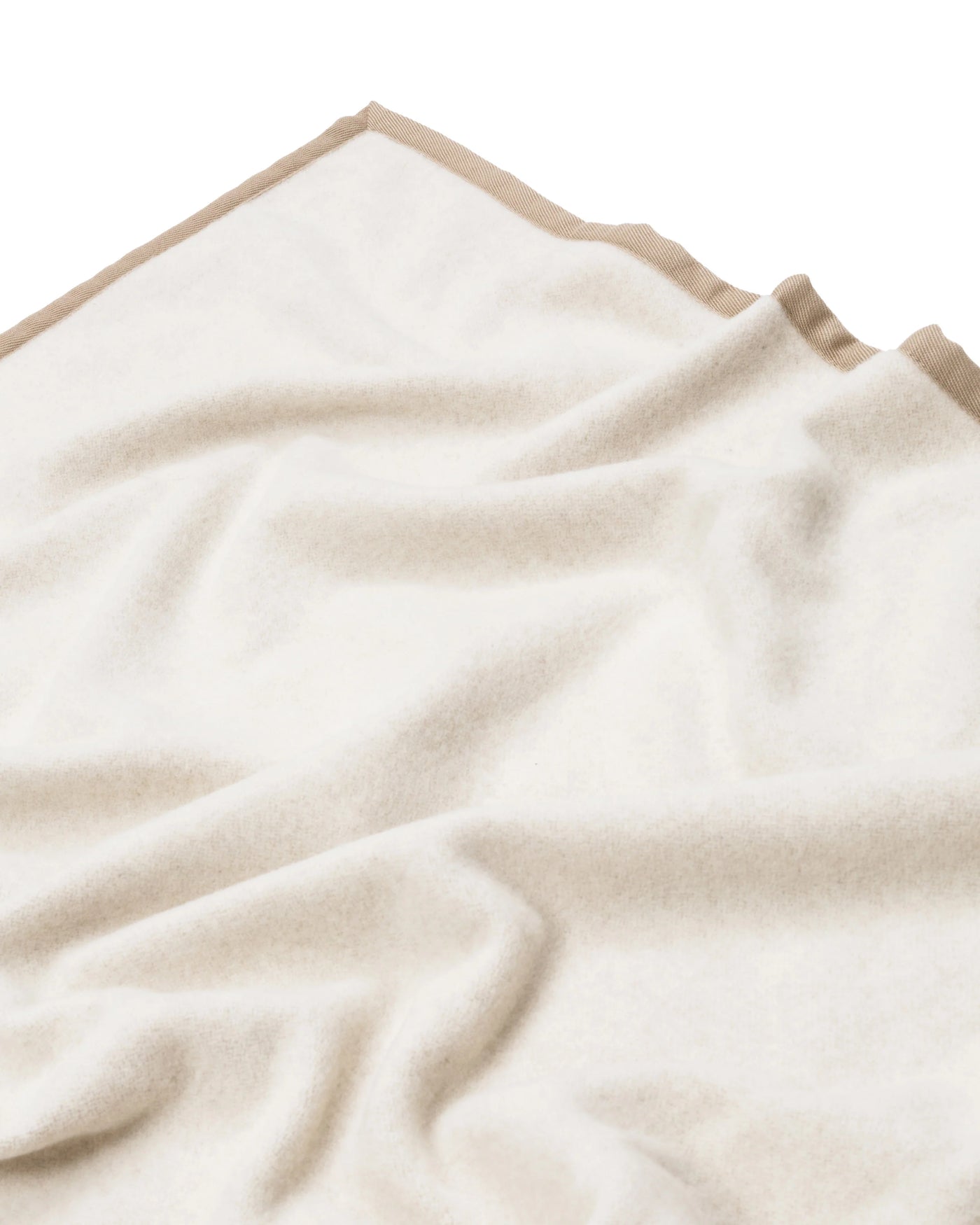Ivory blanket with contrast sand border trim, soft draped fold detail.