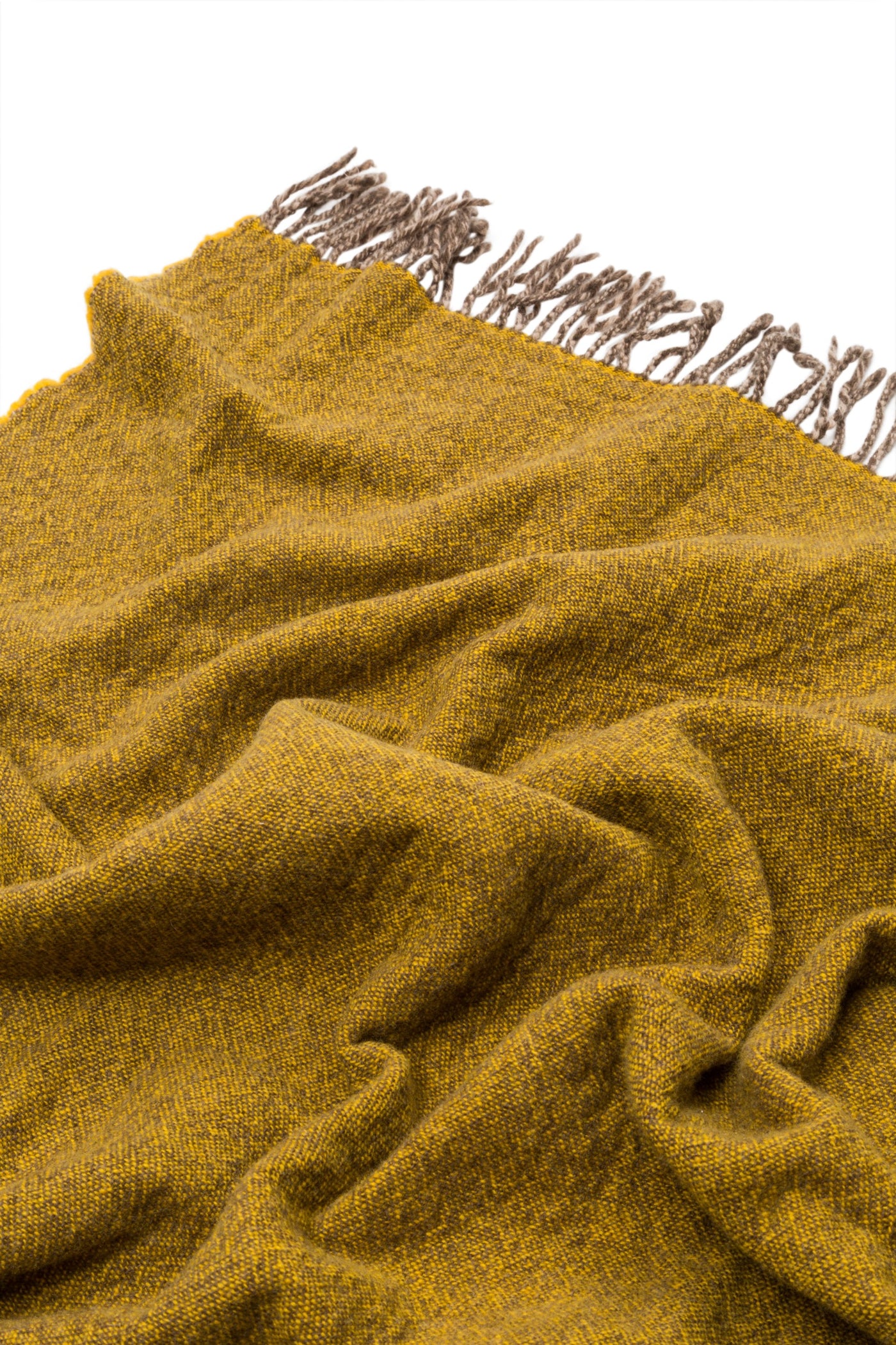 Close-up of saffron bouclé weave throw with twisted taupe fringe edge.