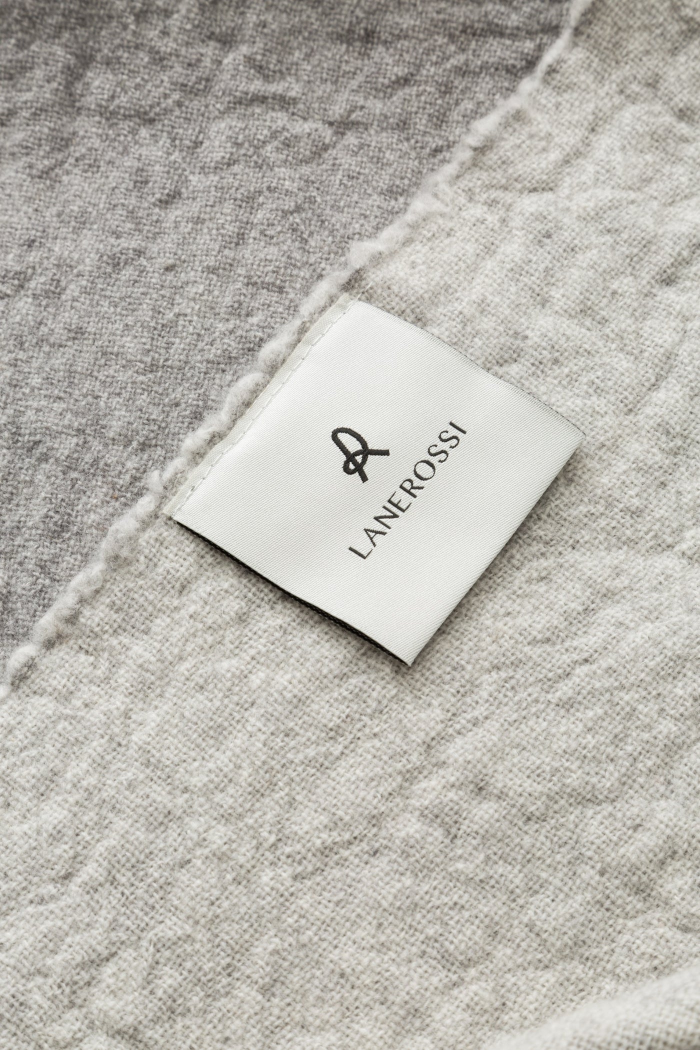 Close-up of Lanerossi label sewn onto a grey textured wool throw.